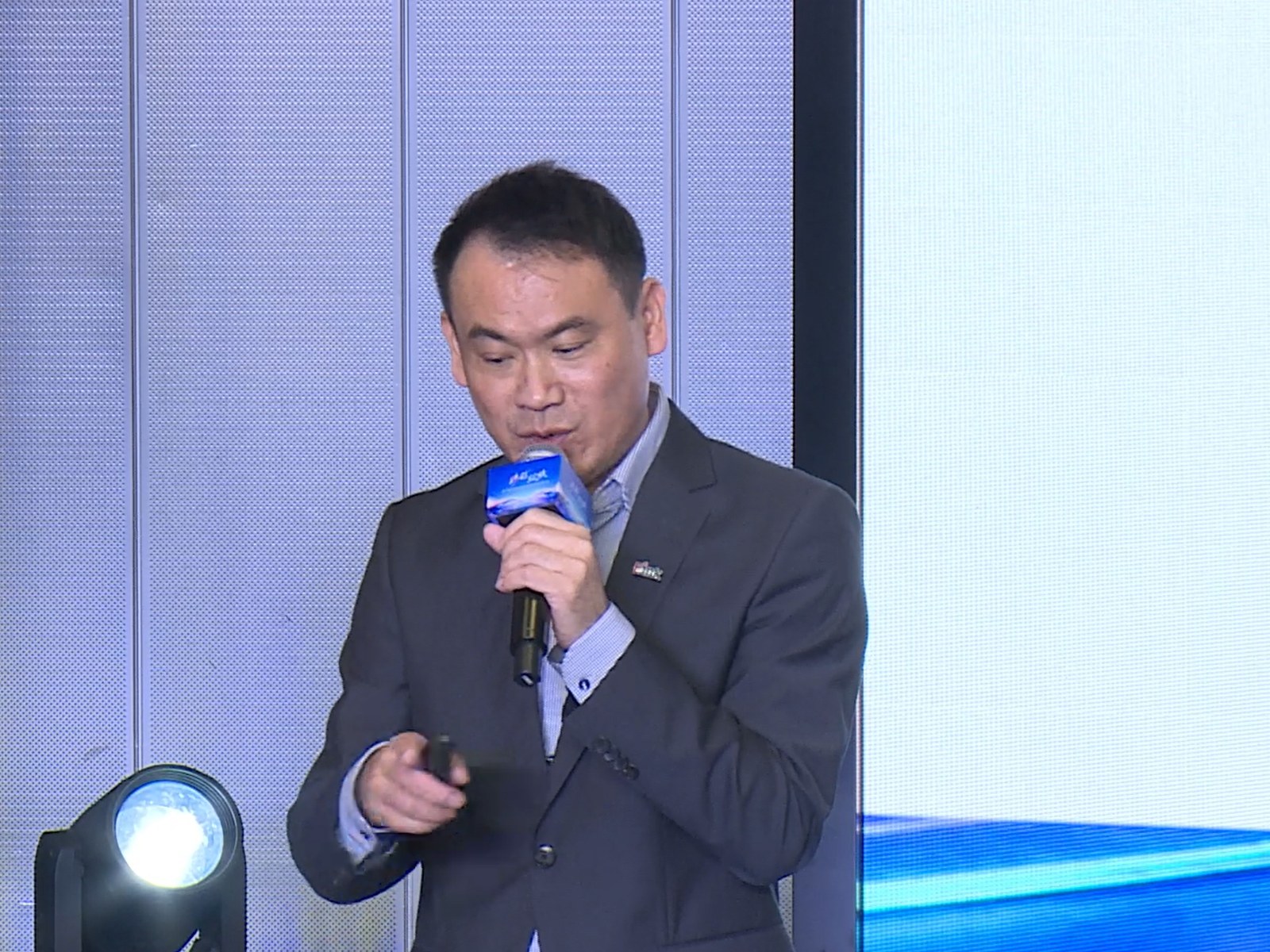 E Ink senior director Gary Chin speaking on stage with a microphone
